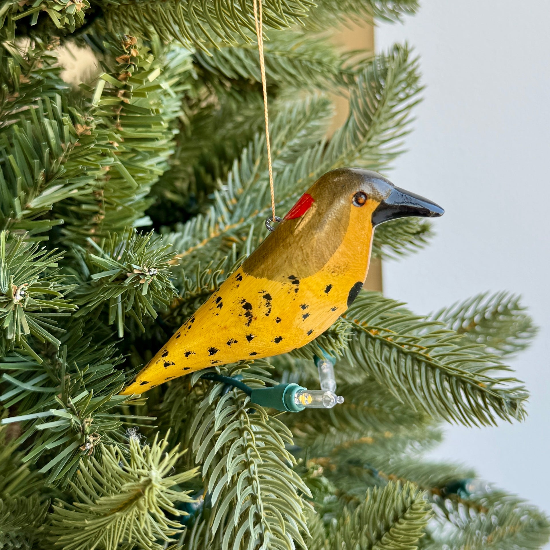 Bird-shaped Christmas ornament hanging on a tree branch