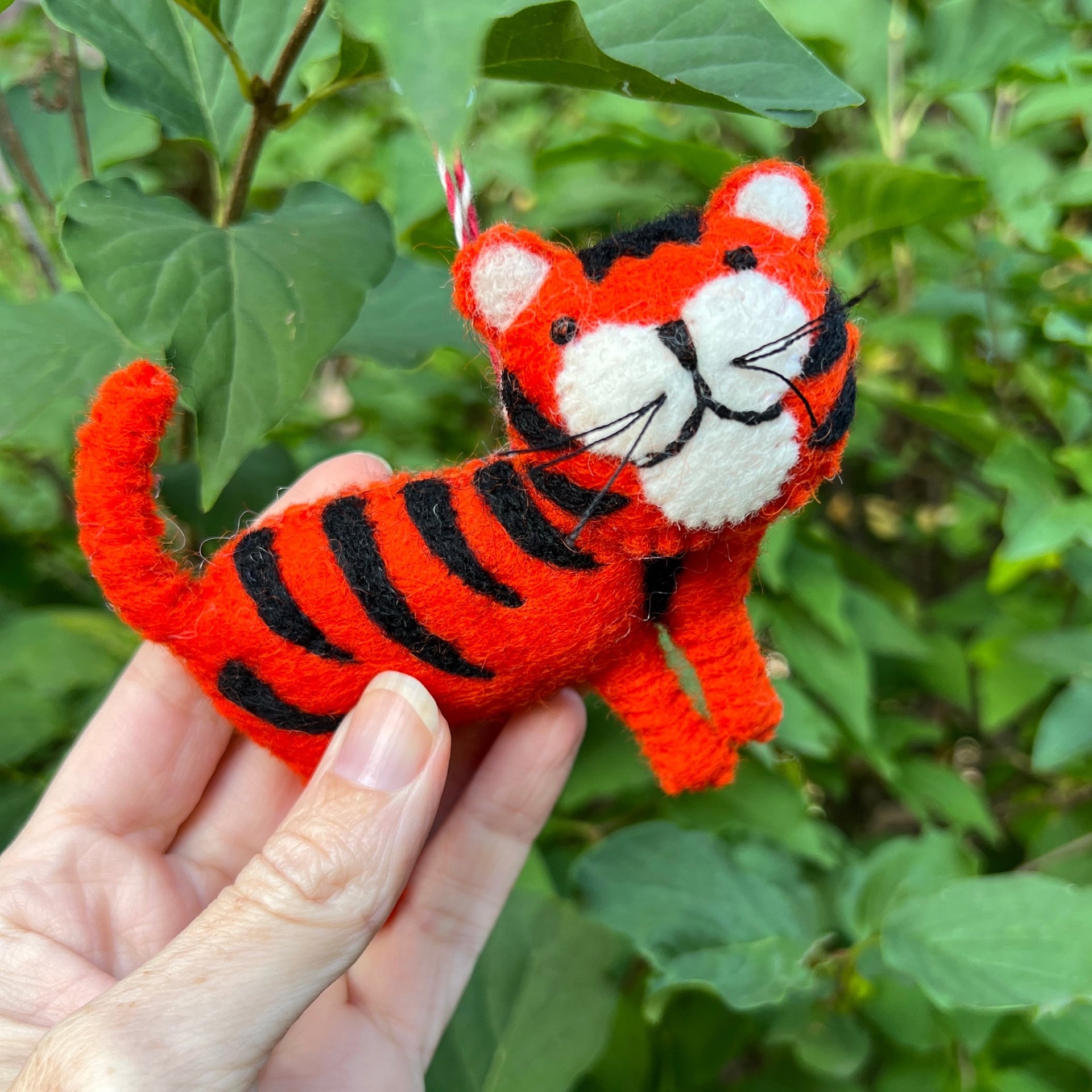cute tiger christmas ornament being help outside