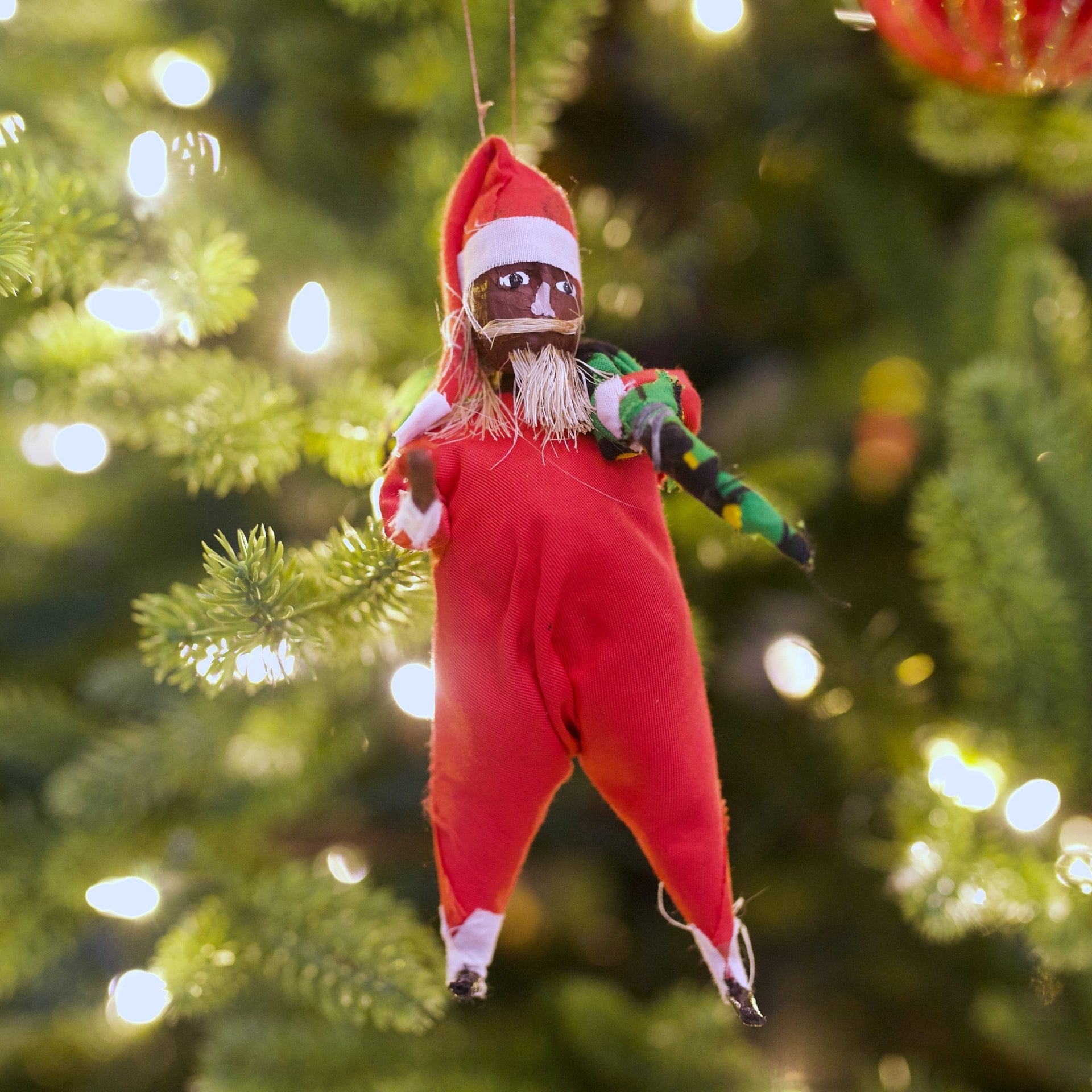 Handmade black Santa ornament from Africa hanging on Christmas tree