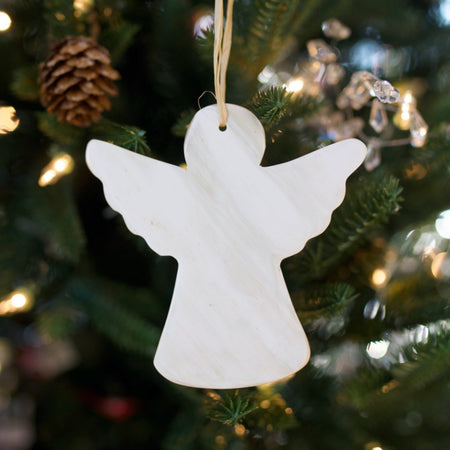 Fair Trade Cow Horn Angel Ornament hanging on a Christmas Tree