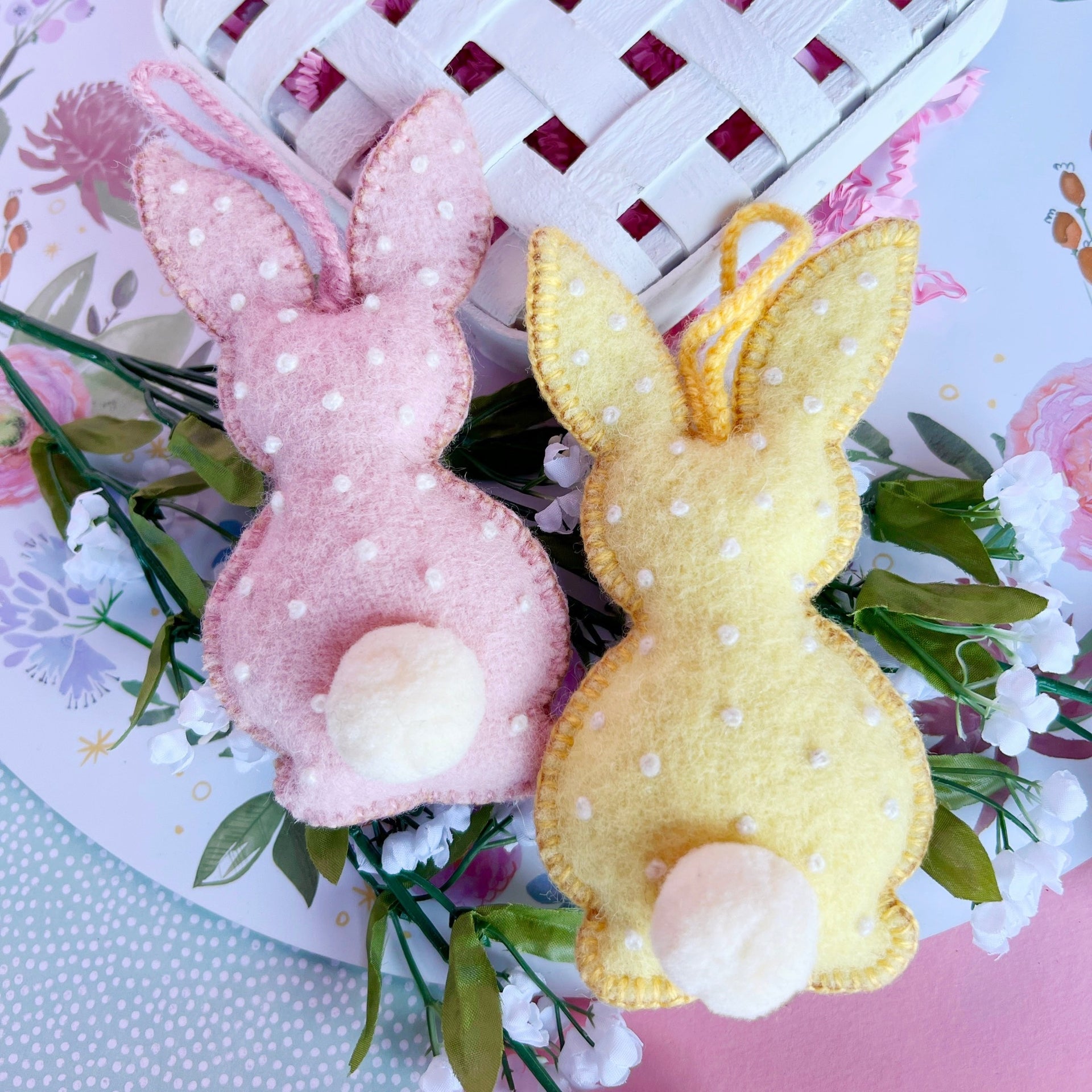 Two handmade Easter bunny Ornaments on a basket. 