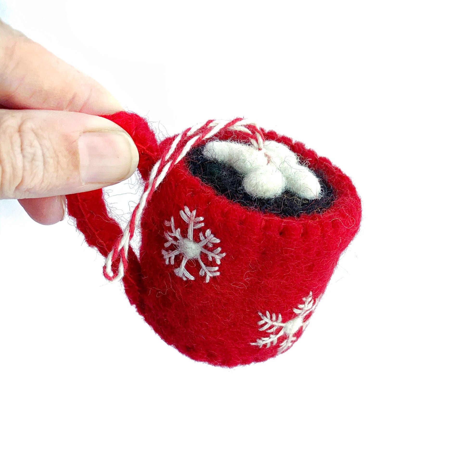 Holding Hot Chocolate Christmas Ornament in fingers