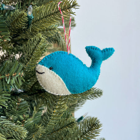 Blue whale ornament hanging on a Christmas tree