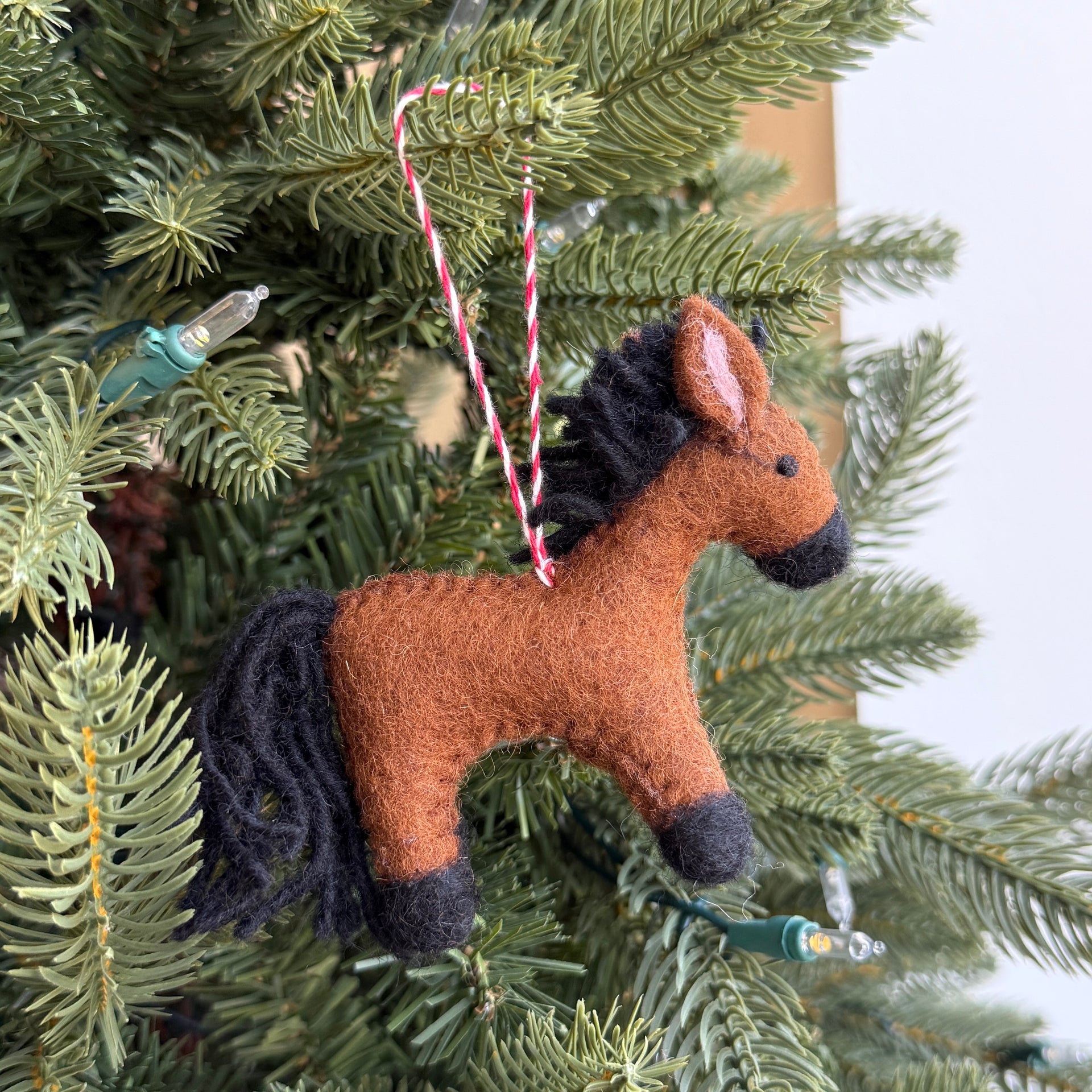 Horse-shaped ornament hanging on a Christmas tree