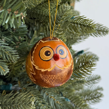 Decorative owl ornament hanging on a Christmas tree