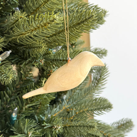 Wooden bird ornament hanging on a Christmas tree