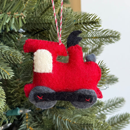 Red felt toy train ornament on a Christmas tree