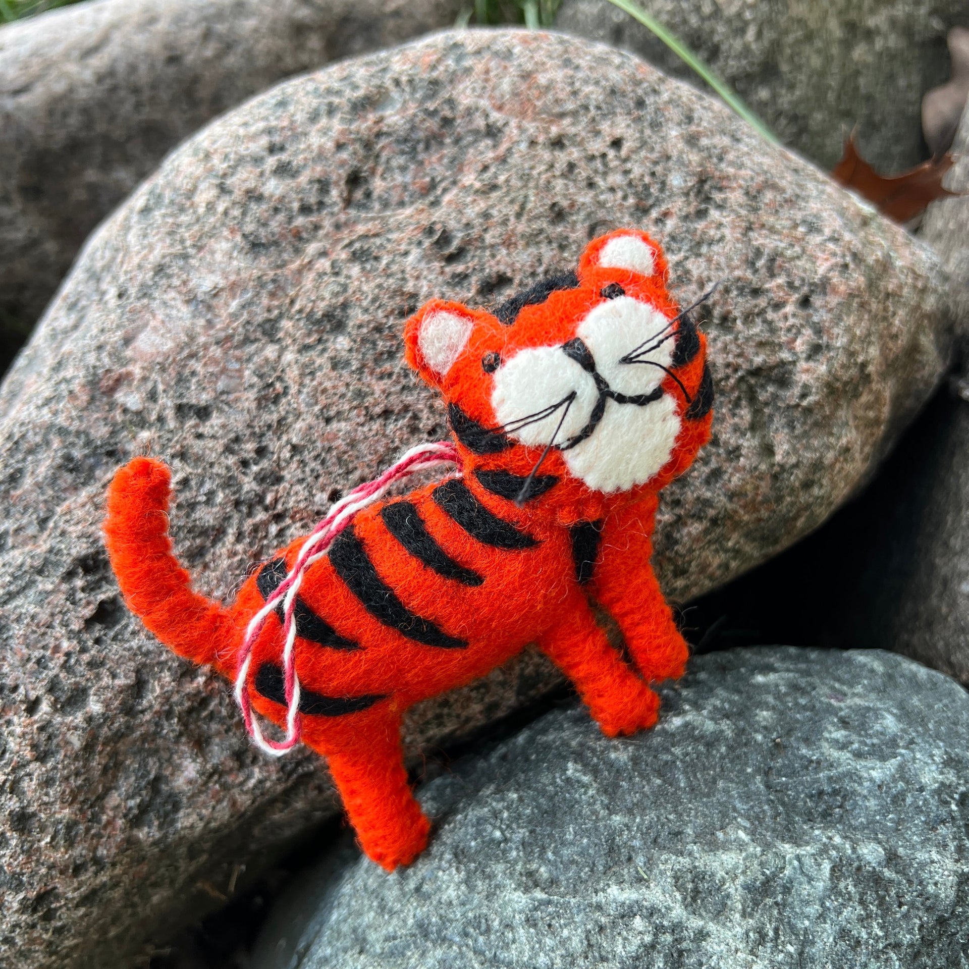 felt tiger ornament standing on rocks
