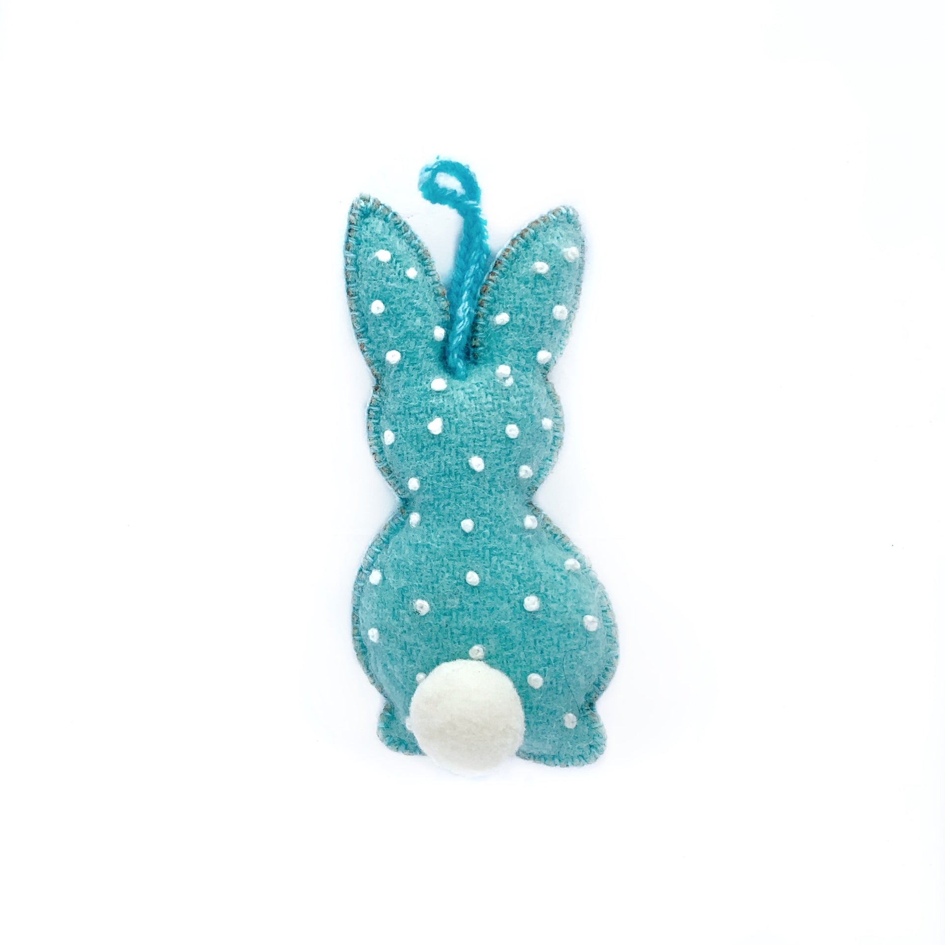 Pastel blue handmade Easter bunny ornament with embroidered white dots and pom pom tail.