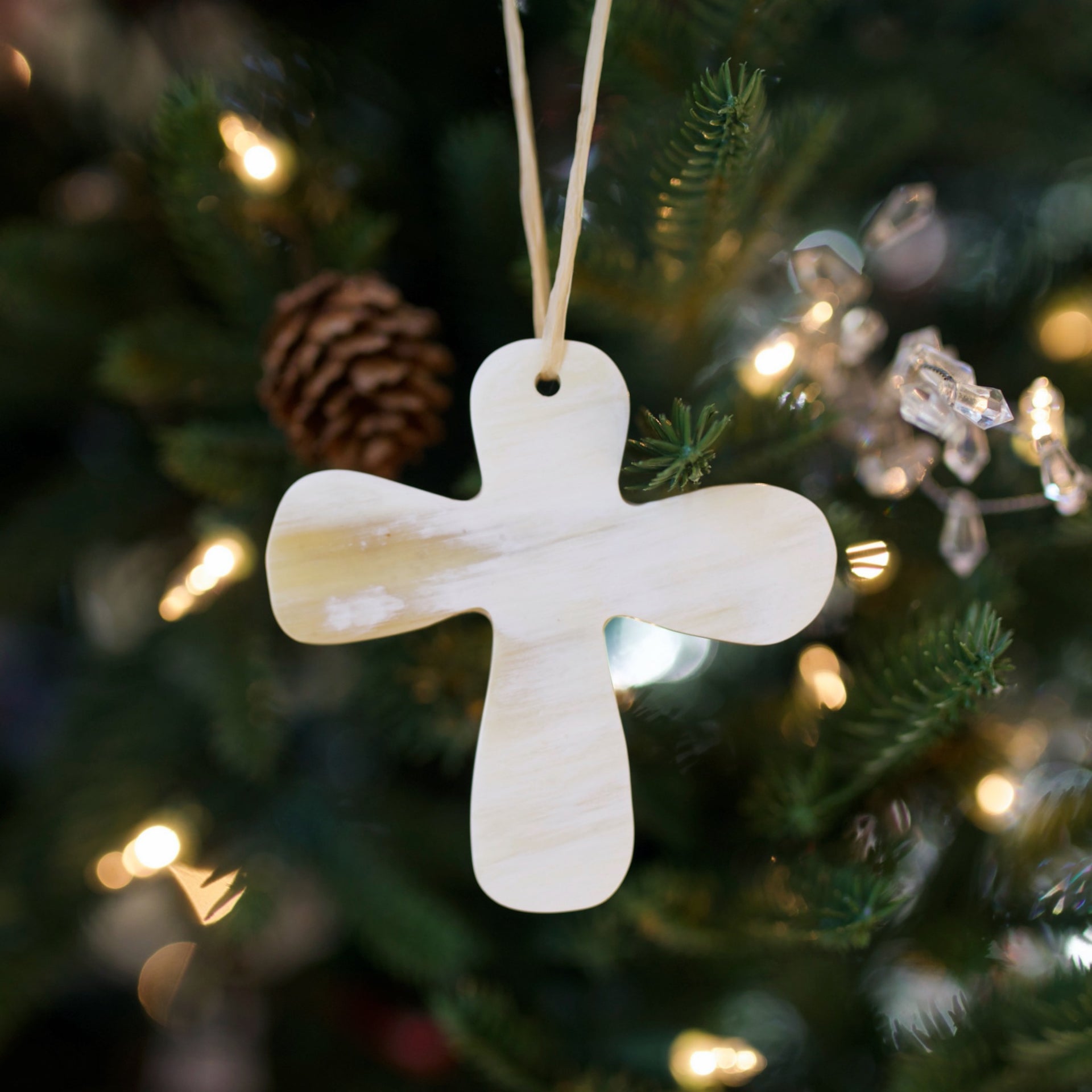 Cow Horn Cross Ornament hanging on an evergreen Christmas tree