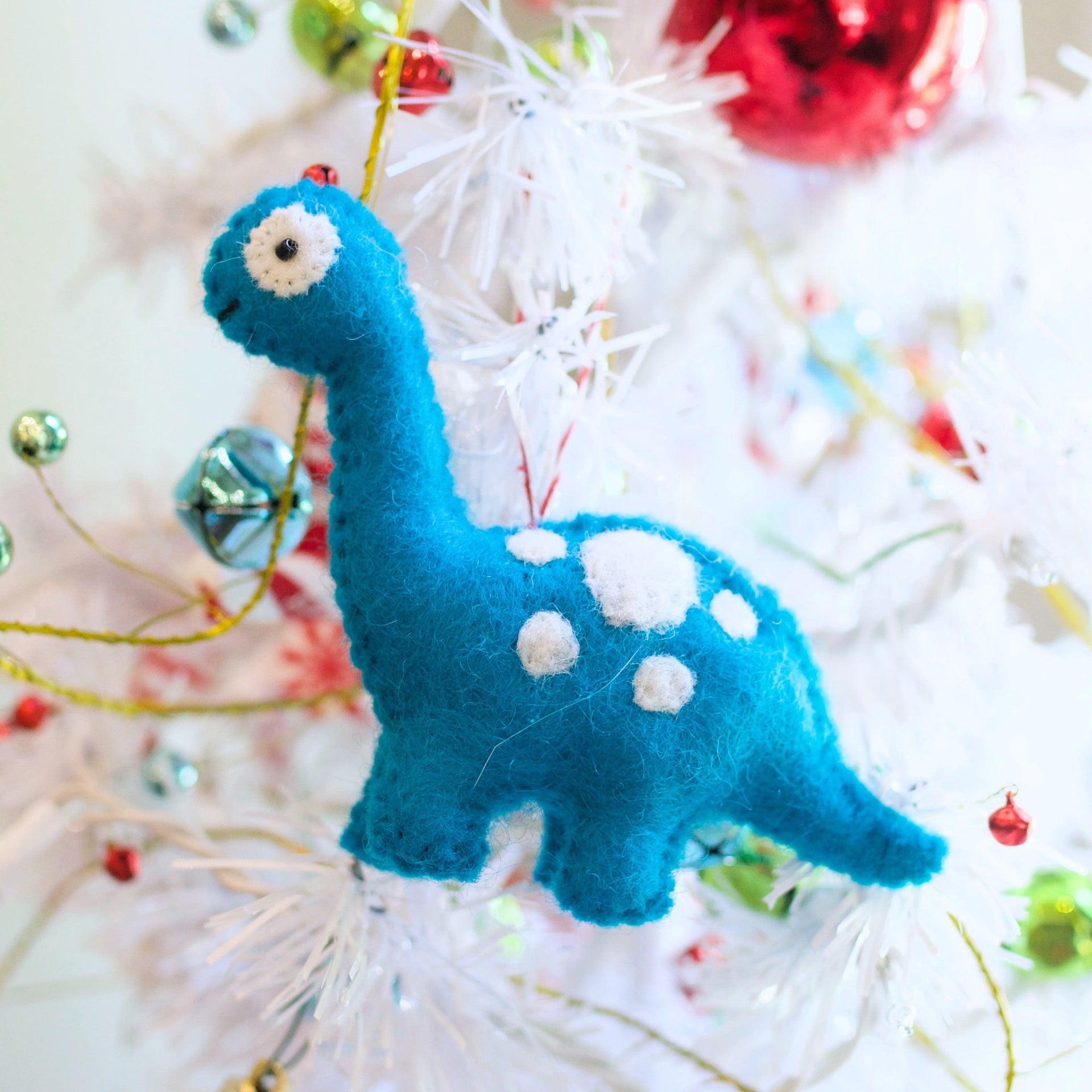 Bright blue dinosaur ornament on Christmas tree