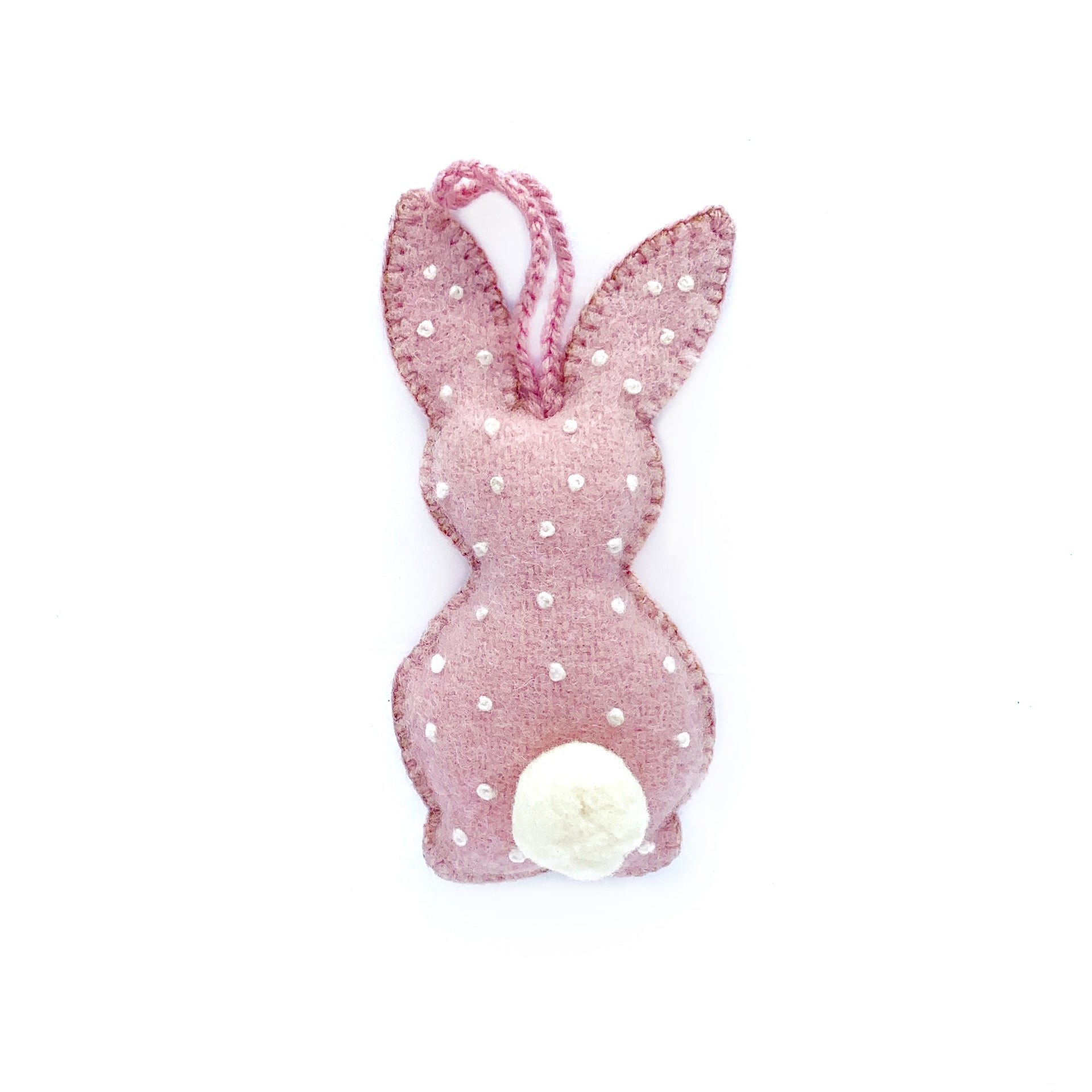 Pastel pink handmade Easter bunny ornament with embroidered white dots and pom pom tail.