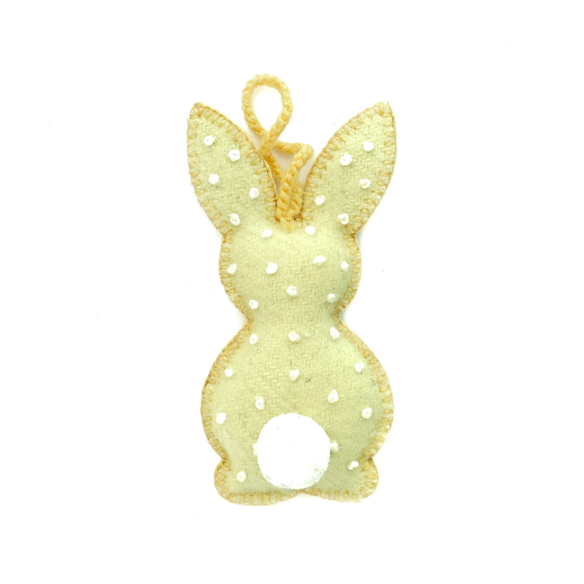 Pastel yellow handmade Easter bunny ornament with embroidered white dots and pom pom tail.